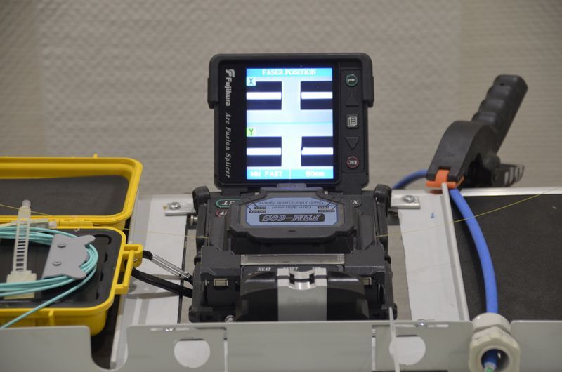Fujikura-Spleißgerät mit geöffnetem Deckel, auf dem Display die Faserpositionen in X- und Y-Achse.